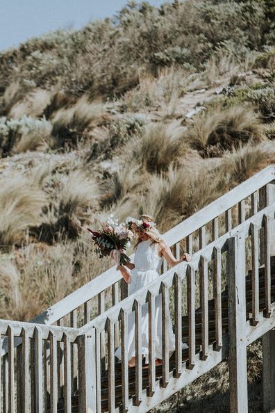 Australian bride and groom surf together before beach wedding