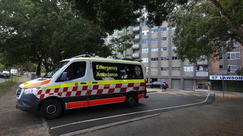 An ambulance is seen departing a housing tower on Morehead Street in Redfern. Health authorities are working to contain an emerging COVID-19 cluster across three social housing towers in the inner-city suburb.