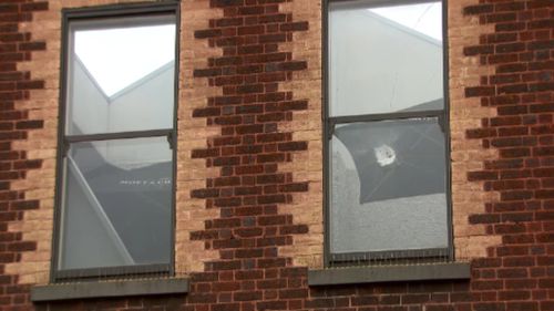 The windows of the club appeared to have been damaged by bullet holes. (9NEWS)