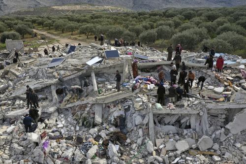 Civil defence workers and residents search through the rubble of collapsed buildings in the town of Harem near the Turkish border, Idlib province, Syria, Monday, Feb. 6, 2023.  