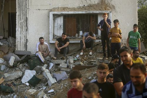 Palestinians inspect the damage of a destroyed house that was hit by an Israeli airstrike in town of Khan Younis, southern Gaza Strip, Tuesday, Oct. 24, 2023.