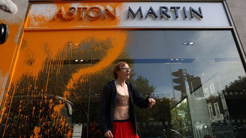 A demonstrator from Just Stop Oil sprays the Aston Martin Store in Mayfair 