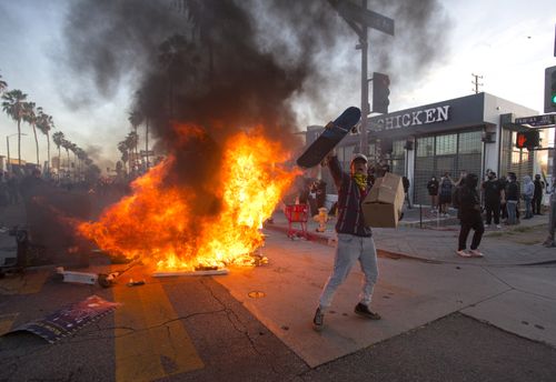 A protester shouts in front of a fire during a protest in Los Angeles