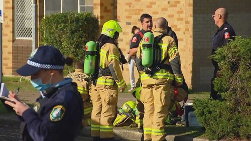 Police and firefighters outside a unit in Malabar following a fire.