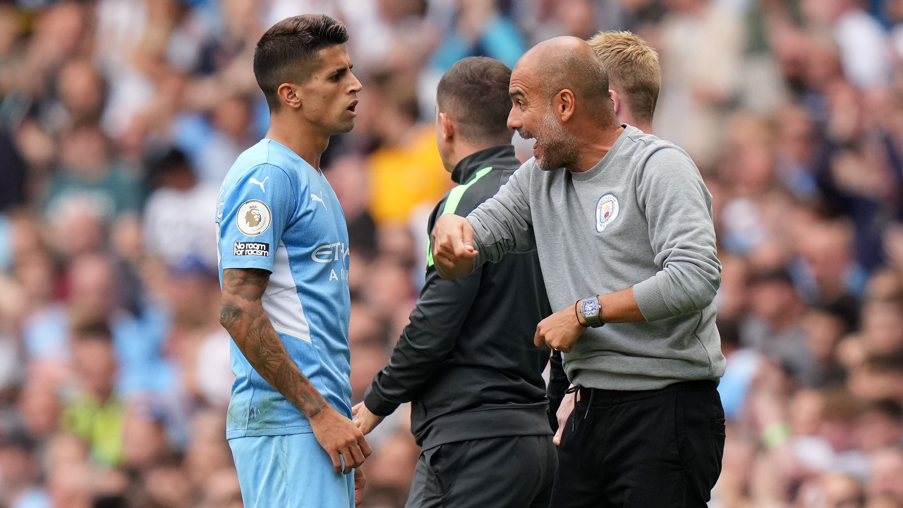 Pep Guardiola, manager of Manchester City talks with Joao Cancelo.
