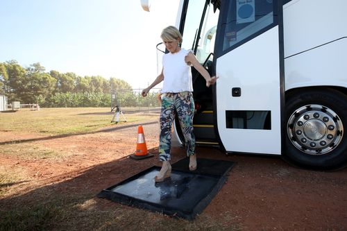 Ms Bishop alights and disinfects her shoes before the tour. Picture: AAP