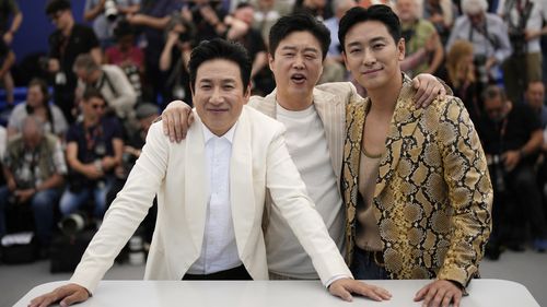 Lee Sun-kyun, from left, Kim Hee-won and Ju Ji-hoon pose for photographers at the Cannes Film Festival in southern France in May.