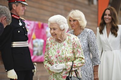 Britain's Queen Elizabeth II , centre, Camilla, the Duchess of Cornwall and Kate, the Duchess of Cambridge, attend an event in celebration of 'The Big Lunch 'initiative, during the G7 summit in Cornwall, England, Friday June 11, 2021. (Oli Scarff/Pool Photo via AP)