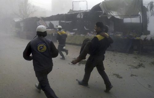 A civil defence worker carries a wounded man after the airstrikes. (Syrian Civil Defense White Helmets via AP)