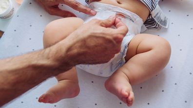 Father change diaper to baby boy on baby changing table