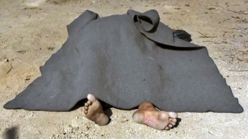 A body covered with a blanket in the street of Qaryatayn. (AP)