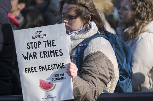 A pro-Palestinian activist holds a banner during session of the International Court of Justice, or World Court, in The Hague, Netherlands, Friday, Jan. 26, 2024. 