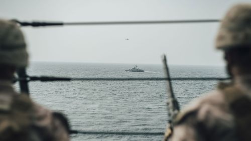 US Marines observe an Iranian fast attack craft from the San Antonio-class amphibious transport dock during a Strait of Hormuz transit.