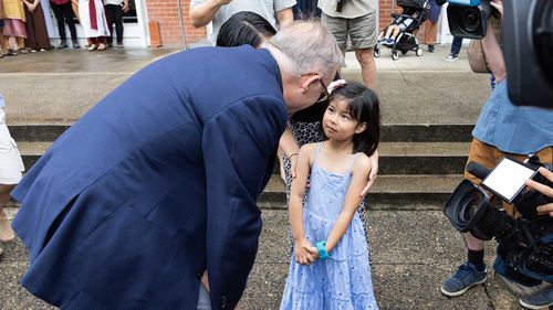 Anthony Albanese speaks to a girl far too young to vote outside a church in Cairns, in the seat of Leichhardt.