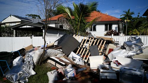 Flood-damaged items and debris are left outside a house in Brisbane.