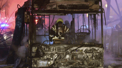 An Israeli firefighter extinguishes a burning bus after it was hit by a rocket fired from the Gaza Strip, at the central Israeli town of Holon, near Tel Aviv.