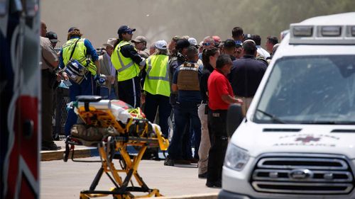 Emergency services and locals gather outside Robb Elementary School in Uvalde, Texas.