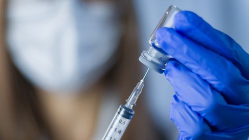 Immagine stock del medico che tiene la siringa per la vaccinazione