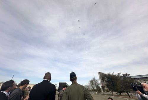 Defence Secretary Lloyd Austin watches as a swarm of five drones takes off from a parking area at the Defense Innovation Unit in Mountain View, Calif, on Friday, Dec. 1, 2023. 
