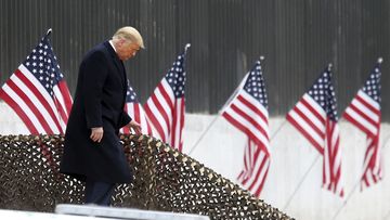 President Donald Trump walks down the steps before a speech near a section of the U.S.-Mexico border wall, Tuesday, Jan. 12, 2021, in Alamo, Texas.