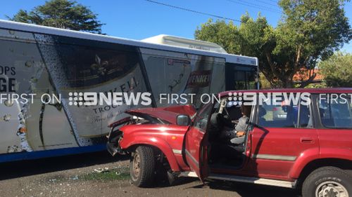 A man in his 50s has been cut free from his car after a collision with a bus. (9NEWS)