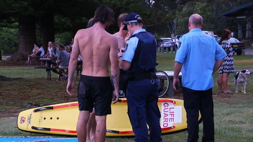 Police speak to onlookers and locals close to Moonee Beach.