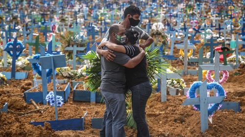 Mourners embrace one another at a graveyard in Manaus, Brazil.