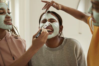 Girls applying cosmetic face masks.