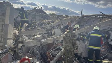 In this photo provided by the Ukrainian Presidential Press Office, emergency workers search the victims of a Russian rocket attack that killed at least 47 people in the village of Hroza near Kharkiv, Ukraine, Thursday, Oct. 5, 2023.