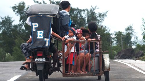 A family is seen here leaving their village for higher ground.