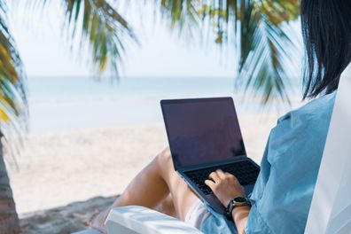 Woman using laptop and smartphone to work study in vacation cady at beach background. Business, financial, trade stock market and social network concept. istock