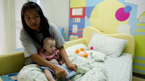 Thai surrogate mother Pattaramon Chanbua (L) holds her baby Gammy, born with Down Syndrome. (NICOLAS ASFOURI/AFP/Getty Images)