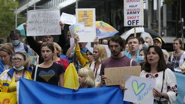 People chant, carry placards and wave Ukrainian flags as they gather in Sydney, Thursday, Feb. 24, 2022, to demonstrate against the attacks in Ukraine. (AP Photo/Rick Rycroft)