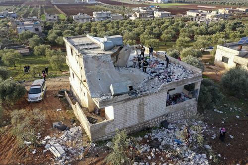 People inspect a destroyed house following an operation by the U.S. military in the Syrian village of Atmeh, in Idlib province, Syria, Thursday, Feb. 3, 2022. 