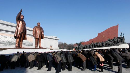 People bow to the bronze statues of their late leaders Kim Il Sung and Kim Jong Il. (AP)
