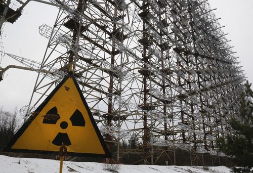 A Soviet-era top secret object Duga, an over-the-horizon radar system once used as part of the Soviet missile defense early-warning radar network, seen behind a radioactivity sign in Chernobyl, Ukraine, on Nov. 22, 2018. 