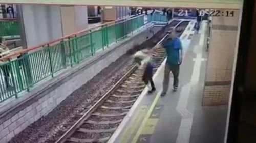 The horrifying moment the cleaner is pushed onto the tracks. (Facebook)