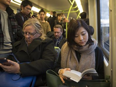 At the end of a workday, commuters ride the subway that travels from Flinders Street Station to points outside the city center of Melbourne, Australia