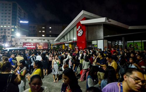 Cebu'daki merkezde deprem sarsıntıları sonrası insanlar bir cadde üzerinde toplanıyor.