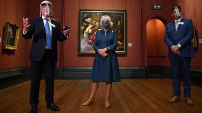 Chair of the Board of Trustees Tony Hall (L) gives a speech as Camilla, Duchess of Cornwall (C) and National Gallery Director Gabriele Finaldi look on during a visit to the recently reopened National Gallery on July 28, 2020 in London, England