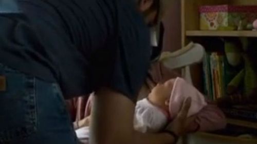 Bradley Cooper (left) picks up the fake baby from Sienna Miller in 'American Sniper'. (Supplied)