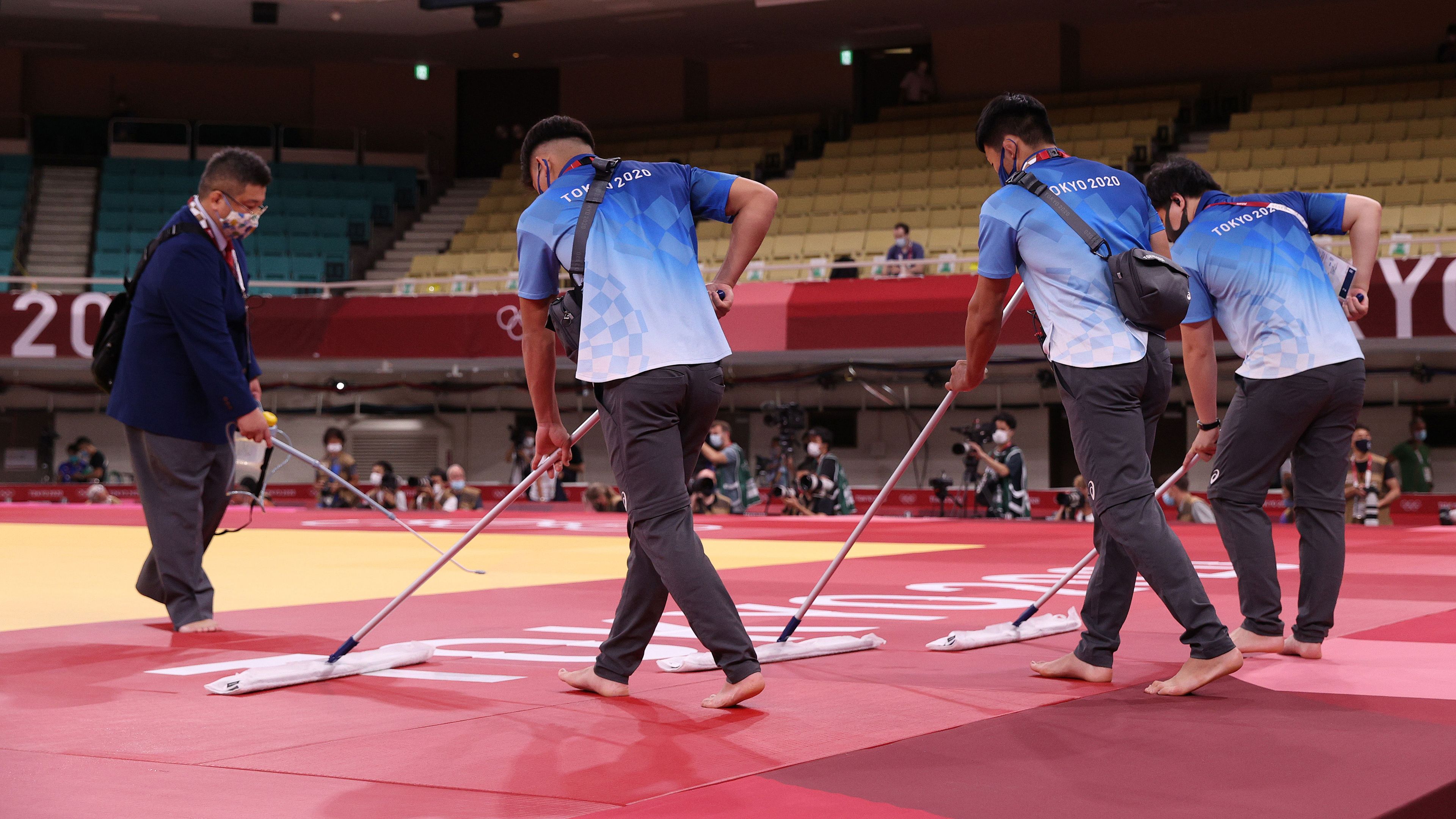 The judo arena is prepared by officials.