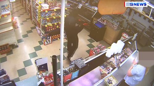 CCTV captured the robber approaching the counter of the IGA supermarket in Wamuran. (9NEWS)