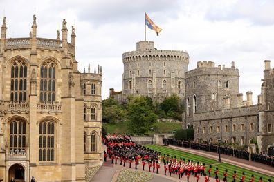 WINDSOR, ENGLAND - SEPTEMBER 19: The coffin of Queen Elizabeth II is carried in The state hearse as it proceeds towards Windsor Castle for The Committal Service for Queen Elizabeth II as the Royal Standard flies above the castle on September 19, 2022 in Windsor, England. The committal service at St George's Chapel, Windsor Castle, took place following the state funeral at Westminster Abbey. A private burial in The King George VI Memorial Chapel followed. Queen Elizabeth II died at Balmoral Castl