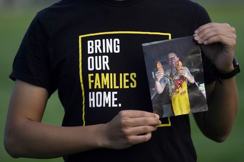 Harrison Li holds a photo of his father Kai Li, 