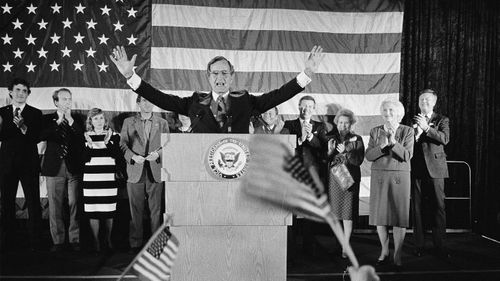 Flag-wavers greet Vice President George Bush after he was re-elected to the post of vice president, in Houston, Texas in 1984. Bush has died at age 94.