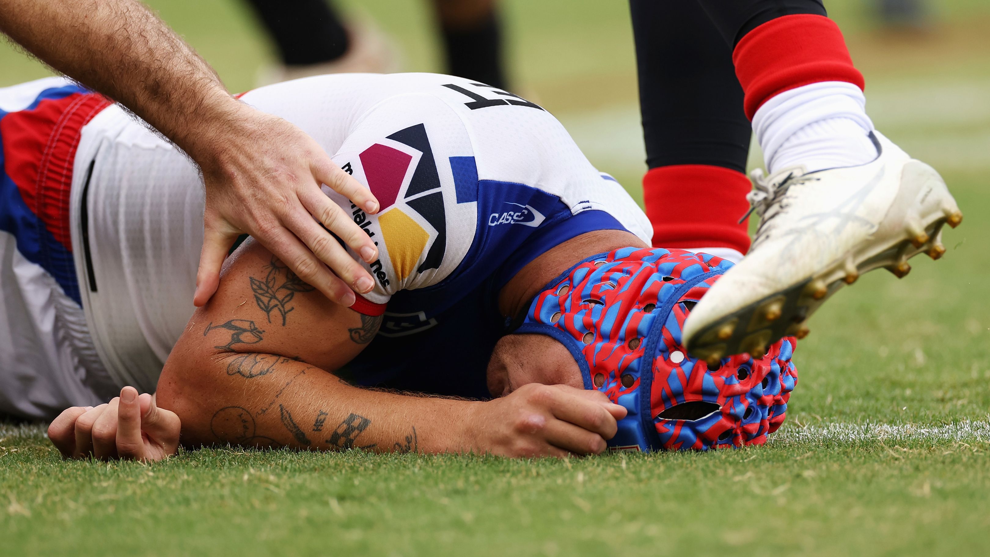 SYDNEY, AUSTRALIA - MARCH 12: Kalyn Ponga of the Knights lays on the ground after colliding with Asu Kepaoa of the Tigers during the round two NRL match between Wests Tigers and Newcastle Knights at Leichhardt Oval on March 12, 2023 in Sydney, Australia. (Photo by Cameron Spencer/Getty Images)