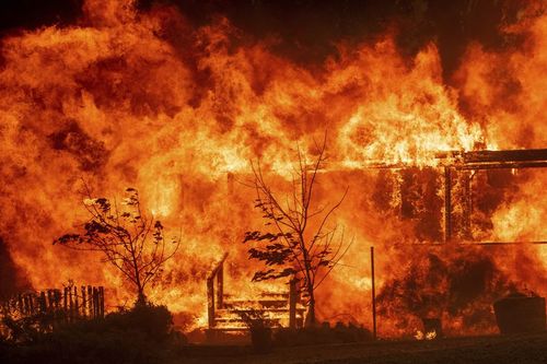 Flames consume a home as the River Fire tears though Lakeport, Calif., on Tuesday, July 31, 2018. (AP Photo/Noah Berger, File