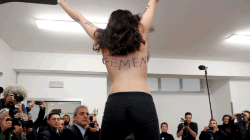 A topless Femen activist protests at a Milan polling station where Silvio Berlusconi was about to vote on Sunday, March 4. (AAP)