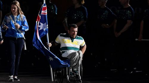 Flagbearer Kurt Fearnley enters the stadium before the start of the closing ceremony, a moment television viewers at home missed out on seeing. (AAP)